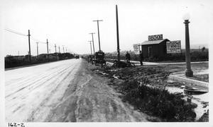 Motorcycle stuck in mud at intersection of West Adams Boulevard and Caldwell Avenue, Los Angeles, 1923