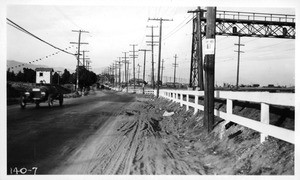 Looking north from Stillwell Avenue along the south side of Huntington Drive showing Pacific Electric embankment and poor condition of roadway adjacent to embankment, Los Angeles, 1922