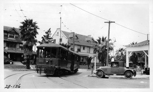 On 11th Street opposite Park View Street looking northwesterly across Hoover Street showing limited clearance for automobiles between curb and street car making turn, Los Angeles, 1928