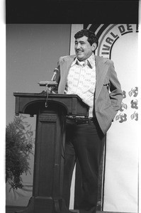 Luis Omar Salinas speaking at a lecturn, Los Angeles, 1973