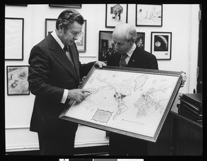 Herbert G. Klein examining a map of world destinations