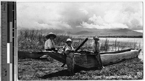 Three boys and a boat on the shore of Lake Patzcuaro, Michoacan, Mexico, ca. 1940-1950