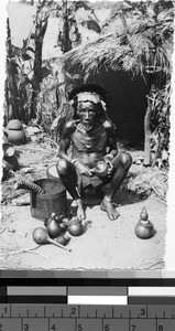 Man making tools outside of a hut, Africa, March 8, 1949