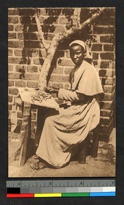 Indigenous nun making lace outdoors, Congo, ca.1920-1940