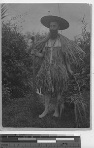 Fr. Jarreau in a raincoat made of palms at Guangzhou , China