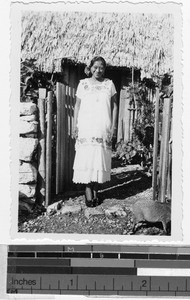 Smiling woman standing in front of the entrance to a house, Quintana Roo, Mexico, ca. 1948