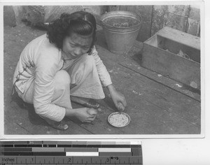 A girl feeding baby ducks at Hong Kong, China, 1941