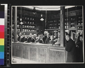 Staff gathered inside medicine shop, China, ca. 1930