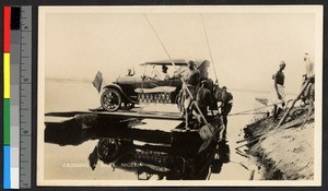 Transporting an automobile across river by raft, Nigeria, ca.1920-1940