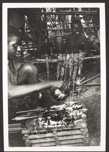 Meat roasted on the spit on the market in Bali. The pieces of meat are stuck onto the split stalks of palm leaves, basted with oil and salt and cooked over the open fire. It is considered to be a great delicacy by the Africans, but may usually only be enjoyed by the men