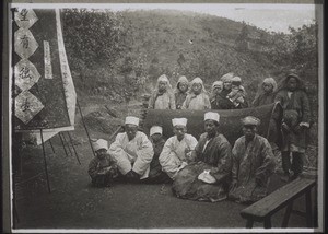 A christian burial in China. The men on the left are wearing white mourning clothes, those on the right, being those most affected by the death, sacks made of hair