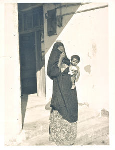 A patient leaves the clinic. She caaries the box with oinment on her head