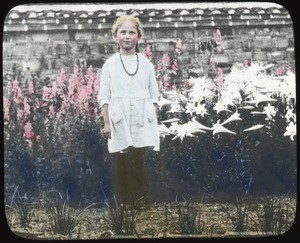 Young girl standing before flowers, Hunan, China, ca.1917-1923