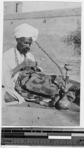 Inidan fakir mending his sacred blanket, India, ca. 1900-1920