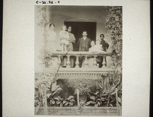 Two missionary families on a veranda. Malapu (Udapi). Mrs Speich and child, the Simons