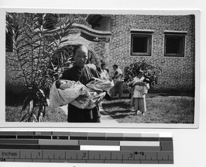 A woman caring for orphan twins at Luoding, China, 1934