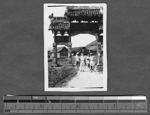 Scientists walking under gate, Sichuan, China, ca.1920-1930