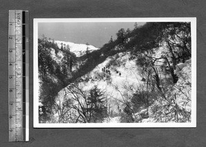 Hiking among snow-covered mountains, China, ca.1941