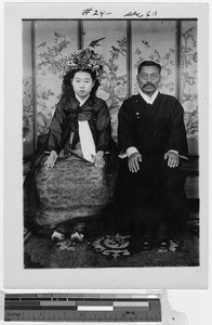 Bride and groom seated in front of a painted screen, Korea, ca. 1920-1940