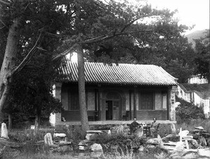 Fr. Anthony Cotta, MM, sitting outside a house, China, ca. 1906-1919