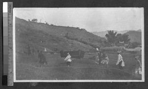 People carrying a cloth-draped item on a pole, Ing Tai, Fujian, China, ca. 1910