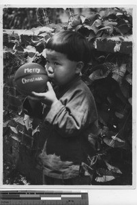 An orphan plays with a Christmas ball at Luoding, China, 1935