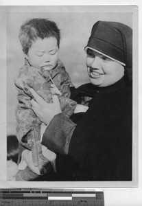 Maryknoll Sister with an orphan at Fushun, China, 1936