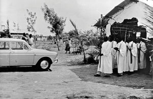 Den gamle kirkebygning i Bukonga, Kagera-regionen, Tanzania, forlades af præsterne i procession - for at indvie den nye kirke, som skimtes i baggrunden. (Anvendt i Dansk Missionsblad nr 6/1967 og DMS Årbog 1967)