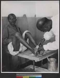 Leprosy patient having his foot bandaged, India, ca.1919-1943