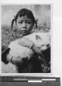 A young girl with a large cat in China