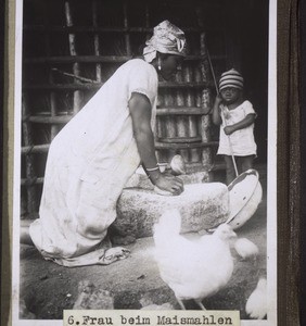 Frau beim Maismahlen
