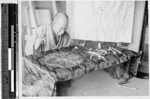 Japanese man embroidering a piece of printed silk, Japan, August 1932