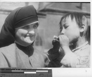 Maryknoll sister with an orphan at Fushun, China, 1937