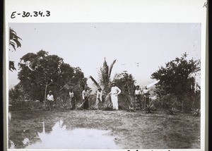 Missionar Ikinger mit Schulknaben beim Reinigen des Stationsgehöftes in Mangamba