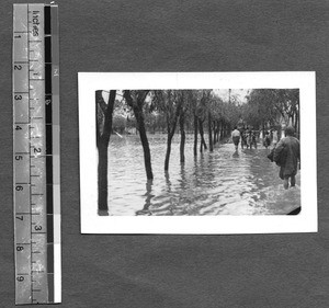 People walking through flood waters at West China Union University, Chengdu, Sichuan, China, 1947