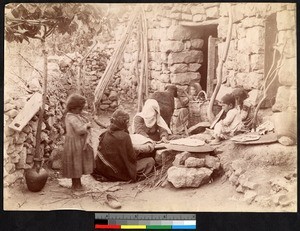 Women and children preparing food outside a stone building, Syria, ca.1856-1910