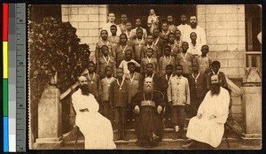 Missionary fathers sit with students who wear medals, Congo, ca.1920-1940