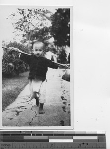 A little boy learning to carry at Luoding, China, 1937