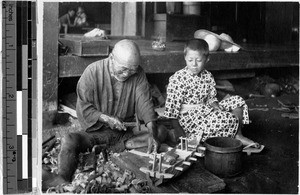 Japanese man building a toy ship, Japan, August 1932