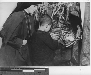 Maryknoll sister teaches child to pray at Fushun, China, 1940