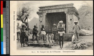 Missionary and other standing before a small stone temple, Tiruvannamalai, India, ca.1920-1940