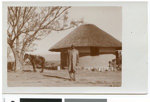 African man in front of a round mud hut, Empangweni, South Africa