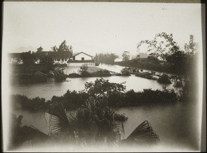 Floods in Honyen. A boat is navigating along a road, on the right. Each year there are floods, often twice a year, 1-2 meter deep