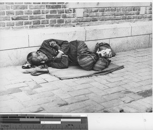 A man sleeping outside the dispensary at Fushun, China, 1939