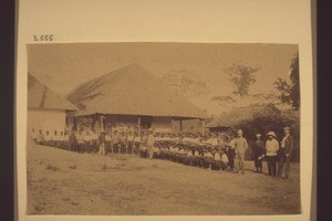 "Kyebi. The expedition ready to march into Asante, July 1900 (see explanation on the rear of the photograph). "According to Rev. O. Ladrach, ex-chaplain of H.M. troops, on 22. Jan. 1947, this photograph was taken in July 1900 in front of the Basel Mission chapel in Kyebi. The photographer...."
