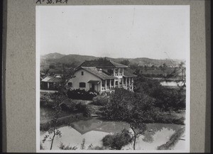 Missionarshaus der Station (Tschonglok). Dasselbe liegt fast direkt am Tschonglokfluss, der die Station von der Stadt trennt. Eine ausgezeichnete Lage, die leider durch periodisch wiederkehrendes Hochwasser etwas beeinträchtigt wird