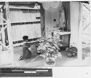 A child prays at an outdoor shrine at Dalian, China, 1940