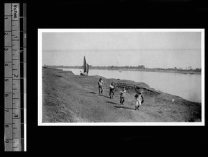 Men towing a houseboat along river, China, ca.1926