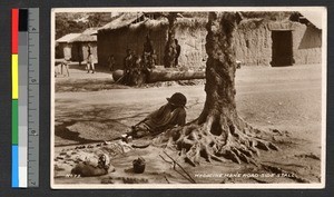 Traditional healer sitting by the roadside, Ghana, ca.1920-1940