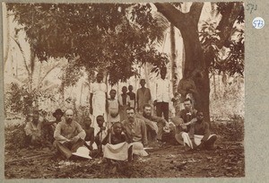 Group picture of 13 African men, women, children and 4 Europeans, ca.1900-1914